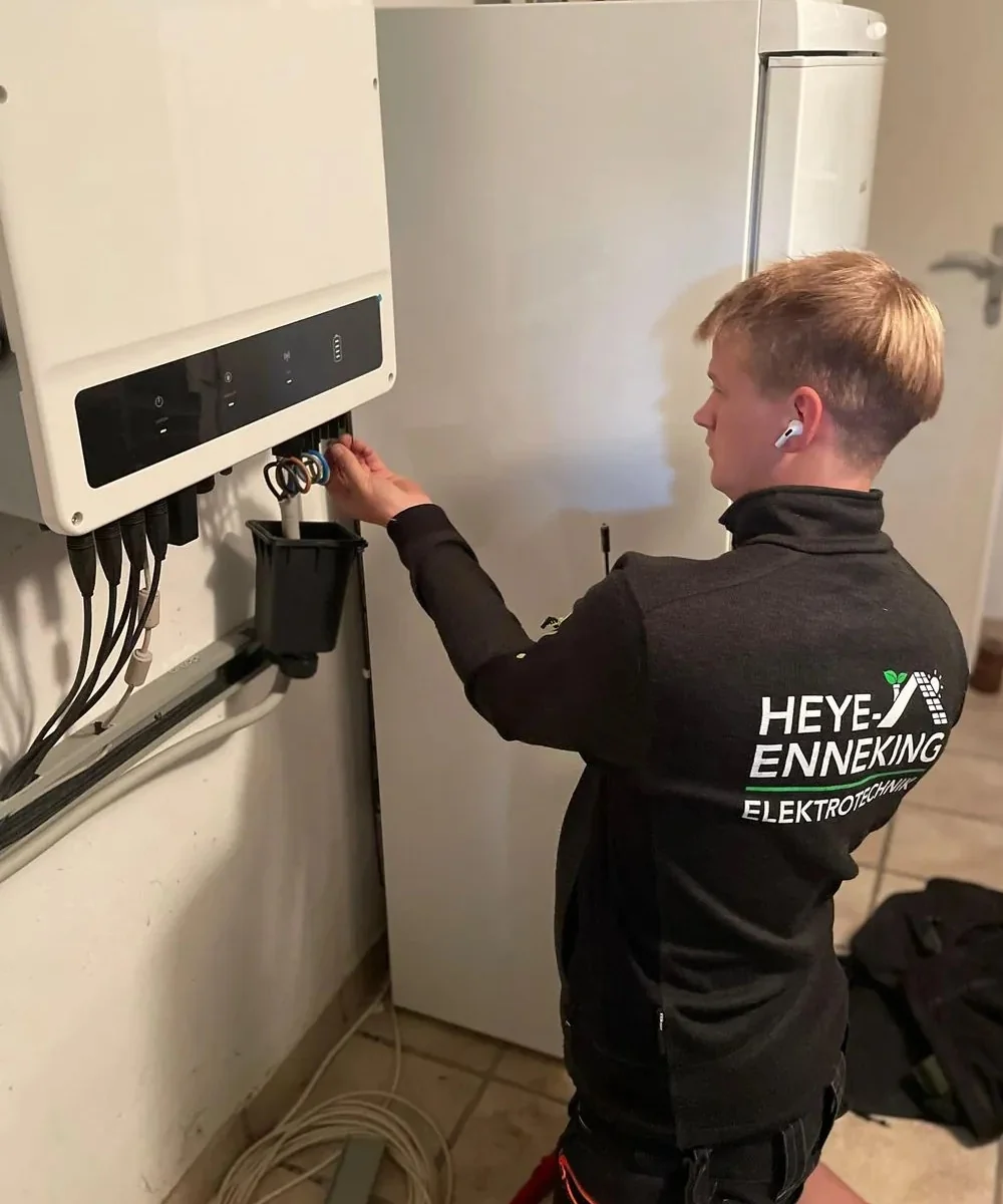 Monteur von Heye-Enneking schließt im Hausanschlussraum einen Batteriespeicher mit Wechselrichter an